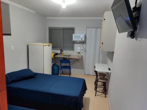a small room with a bed and a television at kitnet individual Campinas in Campinas