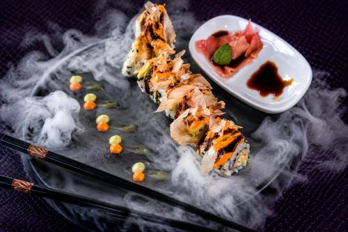 a plate with sushi and a bowl of smoke at The Glenmoriston Townhouse Hotel in Inverness