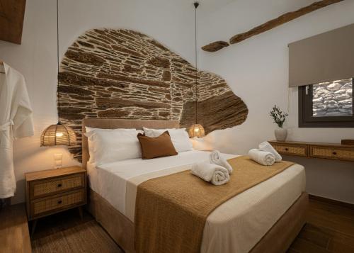 a bedroom with a large bed with towels on it at Lithoskino Suites in Batsi
