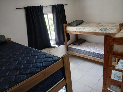 a room with two bunk beds and a window at cabañas cosquin in La Porteña