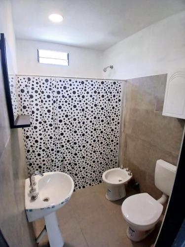 a bathroom with a sink and a toilet at cabañas cosquin in La Porteña