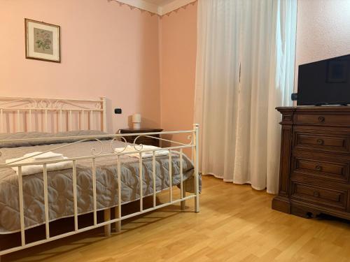 a bedroom with a bed and a dresser and a television at Casa Alessandra in Arezzo