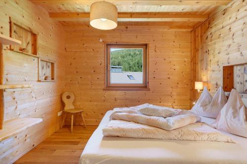 a bedroom with a bed in a wooden cabin at Schwabl Auf Der Ebene in Meltina