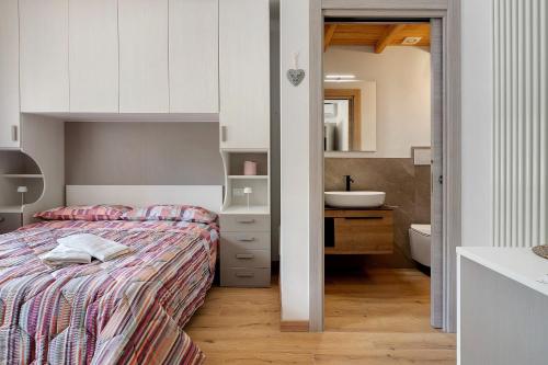a bedroom with a bed and a bathroom with a sink at Casa Aria Pura in Alano di Piave