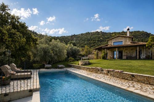 a backyard with a pool and a house at Blue Jasmine Villa - Private Pool and Garden in Aigio