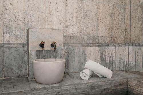 a bathroom with a tub and a roll of toilet paper at Boutique Hotel Ukus in Tešanj