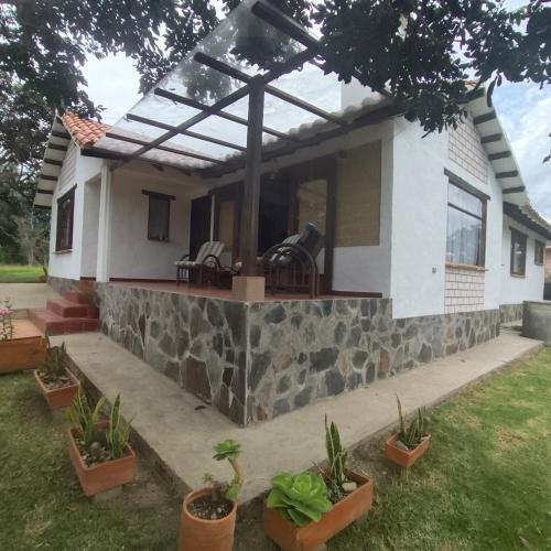 a house with a glass roof and some plants at Hospedaje Casa Campestre Pistacia Vera - Villa de Leyva in Villa de Leyva