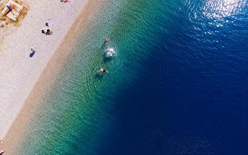 an overhead view of a beach with people in the water at Blue Jasmine Villa - Private Pool and Garden in Aigio