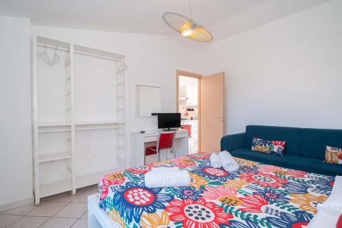 a bedroom with a bed and a blue couch at New Naxian Holidays in Giardini Naxos