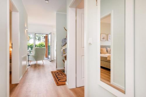 a hallway with a room with a bed and a chair at FeWo Lieblingsplatz in Zingst