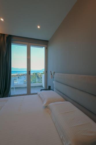 a bedroom with a large bed with a large window at The Real Sea View Hotel Vlore in Vlorë