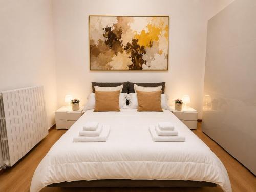 a bedroom with a large white bed with two tables at Maison Arche' relax e spazio a Sannicandro in Sannicandro di Bari