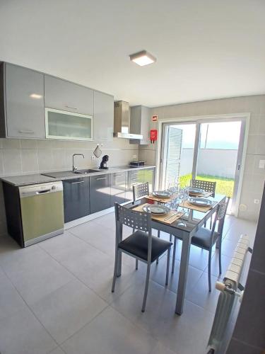 a kitchen with a table and chairs and a kitchen with a window at Casa Estradinha Azul in Amarante