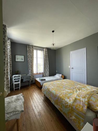 a bedroom with a large bed and a window at Chambre d'Hôte des Arcs in Coulonces