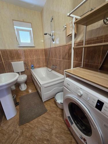 a bathroom with a washing machine and a sink at Villa Crown Silvia in Dobra Voda