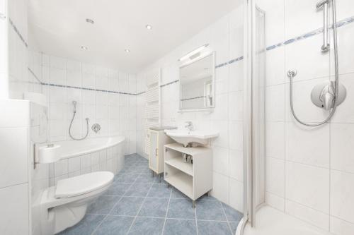a white bathroom with a toilet sink and a shower at Haus St. Christoph in Mayrhofen
