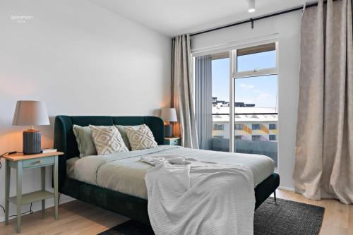 a bedroom with a bed and a large window at Premium Ice Apartments Atlantic Ocean Magic View in Reykjavík