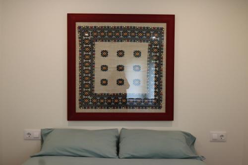 a picture above a bed with a picture on the wall at Xeitosa II, en el centro de Vigo in Vigo