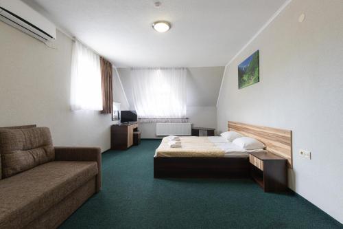 a hotel room with a bed and a couch at Hotel Restaurant Vizit in Truskavets