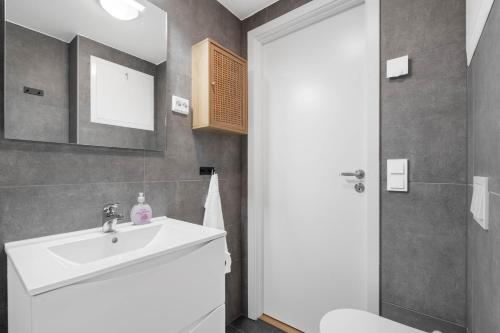 a bathroom with a sink and a toilet at Helt ny leilighet in Leknes