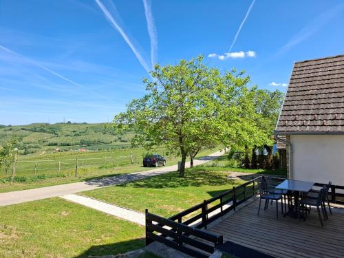 a deck with a table and chairs on a house at Mecsek Vendégház in Mecseknádasd