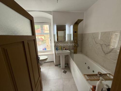 a bathroom with a tub and a sink and a toilet at Downtown luxury segment in Braşov