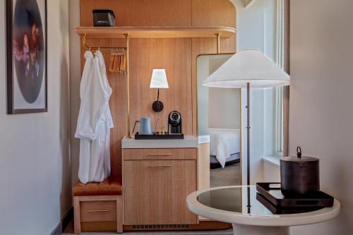 a room with a table and a room with a bed at The Beacon at Embassy Row, WorldHotels Distinctive in Washington, D.C.