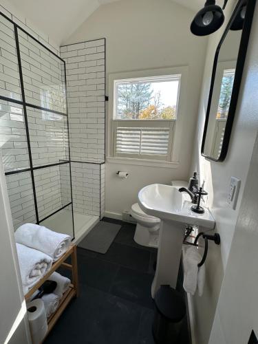 a bathroom with a sink and a toilet and a window at Cabin Oasis near Town in Catskill