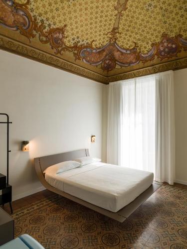 a bedroom with a large bed with a gold ceiling at Palazzo Settanta in Catania