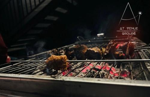 a grill with chicken and other food on it at At Venue Groups in Kodaikānāl