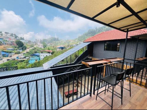 a balcony with a table and chairs and a view at At Venue Groups in Kodaikānāl