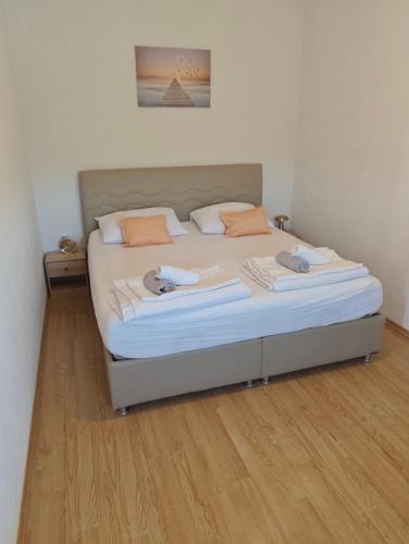 a bedroom with a large bed with two pillows at Apartman Daniela in Neum