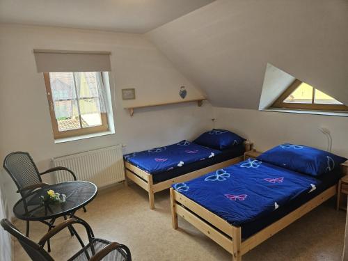 a bedroom with two beds and a table and a chair at Občerstvení u cyklostezky in Břehov