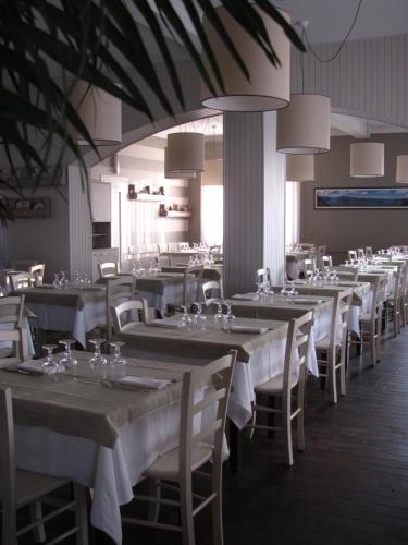 une salle à manger avec tables et chaises et nappes blanches dans l'établissement Albergo La Genzianella, à Miasino