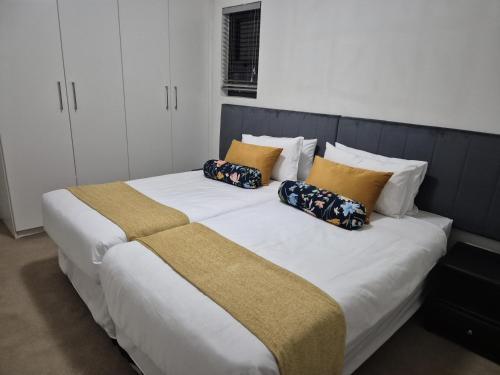 a large bed with pillows on it in a bedroom at Elegant Bliss -2 bedroomed at Dainfern, in Fourways, Sandton in Fourways