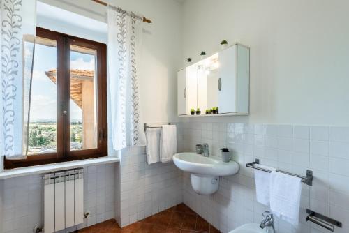 a white bathroom with a sink and a window at Appartamento BePlace - Subborgo in Rapolano Terme