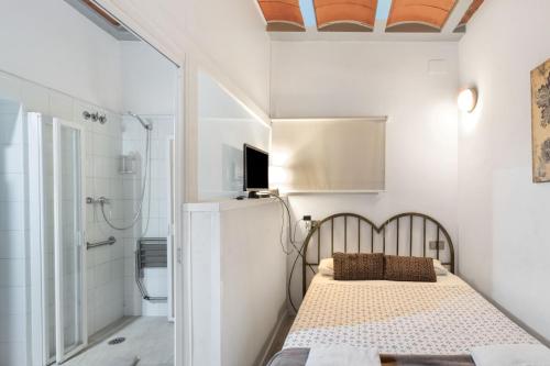 a small bedroom with a bed and a shower at Can Lluís in Capellades