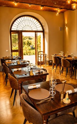 a restaurant with tables and chairs and a large window at Il Cerchio delle Streghe Country House al Podere Casella in Castiglione dʼOrcia