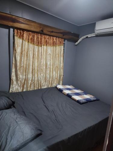 a bed in a room with a window at Aaqib Homestay in Suva