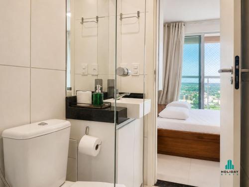 a bathroom with a toilet and a sink and a bed at Fortaleza Sul by Holiday Stays in Fortaleza