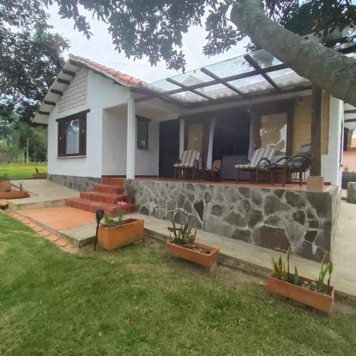 a house with a stone wall and a patio at Hospedaje Casa Campestre Pistacia Vera - Villa de Leyva in Villa de Leyva