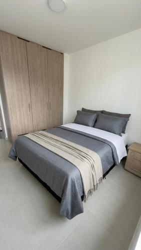a bedroom with a large bed in a white room at Apartamento Vergel in Ibagué