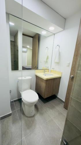 a bathroom with a toilet and a sink and a mirror at Apartamento Vergel in Ibagué
