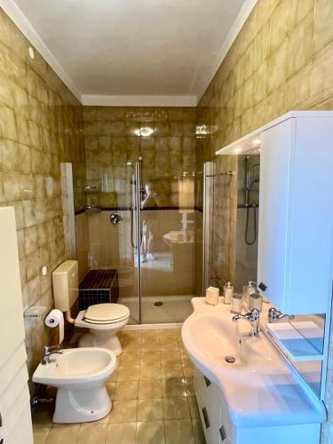 a bathroom with a toilet and a sink and a shower at Motor Rooms in Maranello