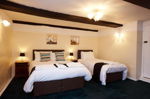 A bed or beds in a room at The Black Swan Inn
