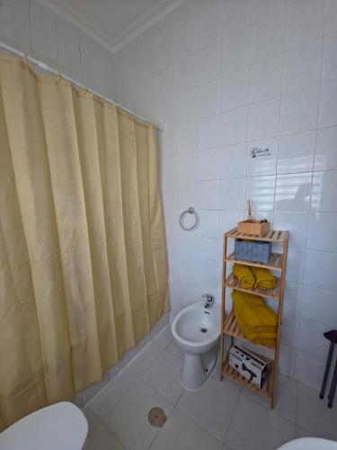 a bathroom with a shower curtain and a sink at Garça-Real 1 in Vale de Madeiros