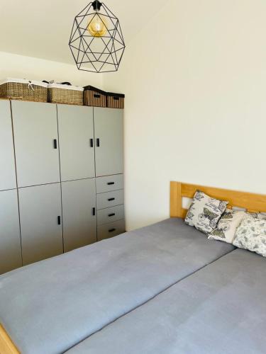 a bedroom with a bed with white cabinets at Sedlinka Klíny in Klíny