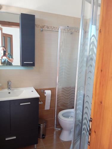 a bathroom with a toilet and a glass shower at Stamoulis Garden House in Katigiorgis