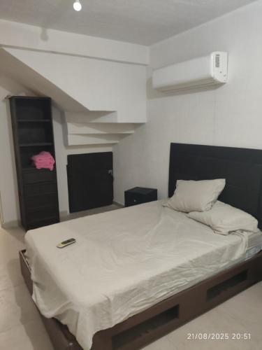 a bedroom with a bed with a phone on it at casa confortabla y relajante con alberca y laguna in Monterrey