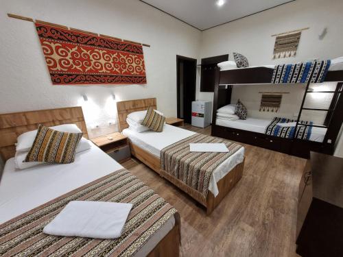 a room with two beds and a bunk bed at Apricot Lodge in Bishkek